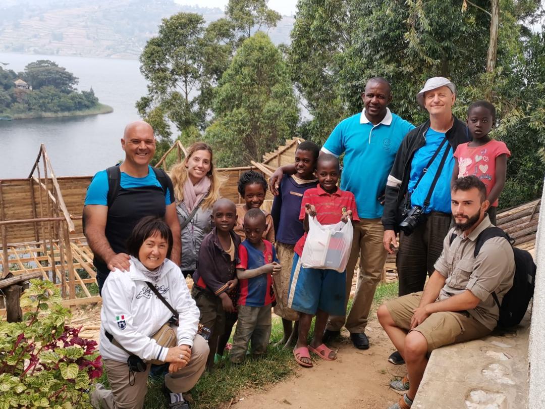 Foto gruppo turisti occidentali con famiglia ugandese
