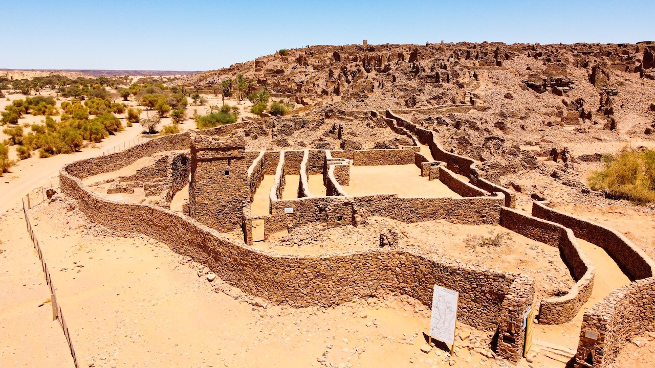 Rovine di edifici storici in pietra a Ouadane, nel deserto, con un paesaggio roccioso.