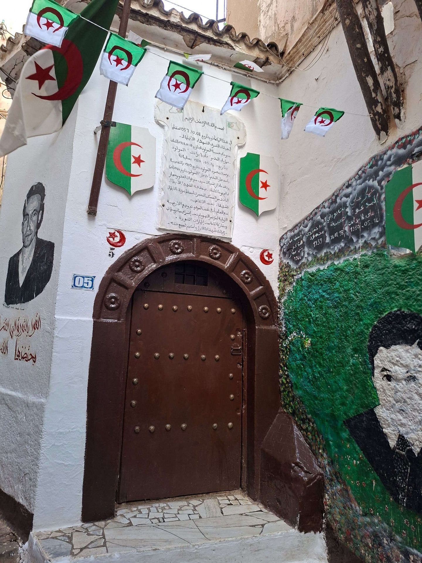 Porta storica della Casbah di Algeri decorata con bandiere algerine e murales dedicati ai martiri della rivoluzione
