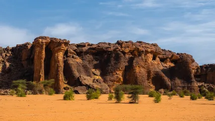 Paesaggio arido con formazioni rocciose e vegetazione sparsa